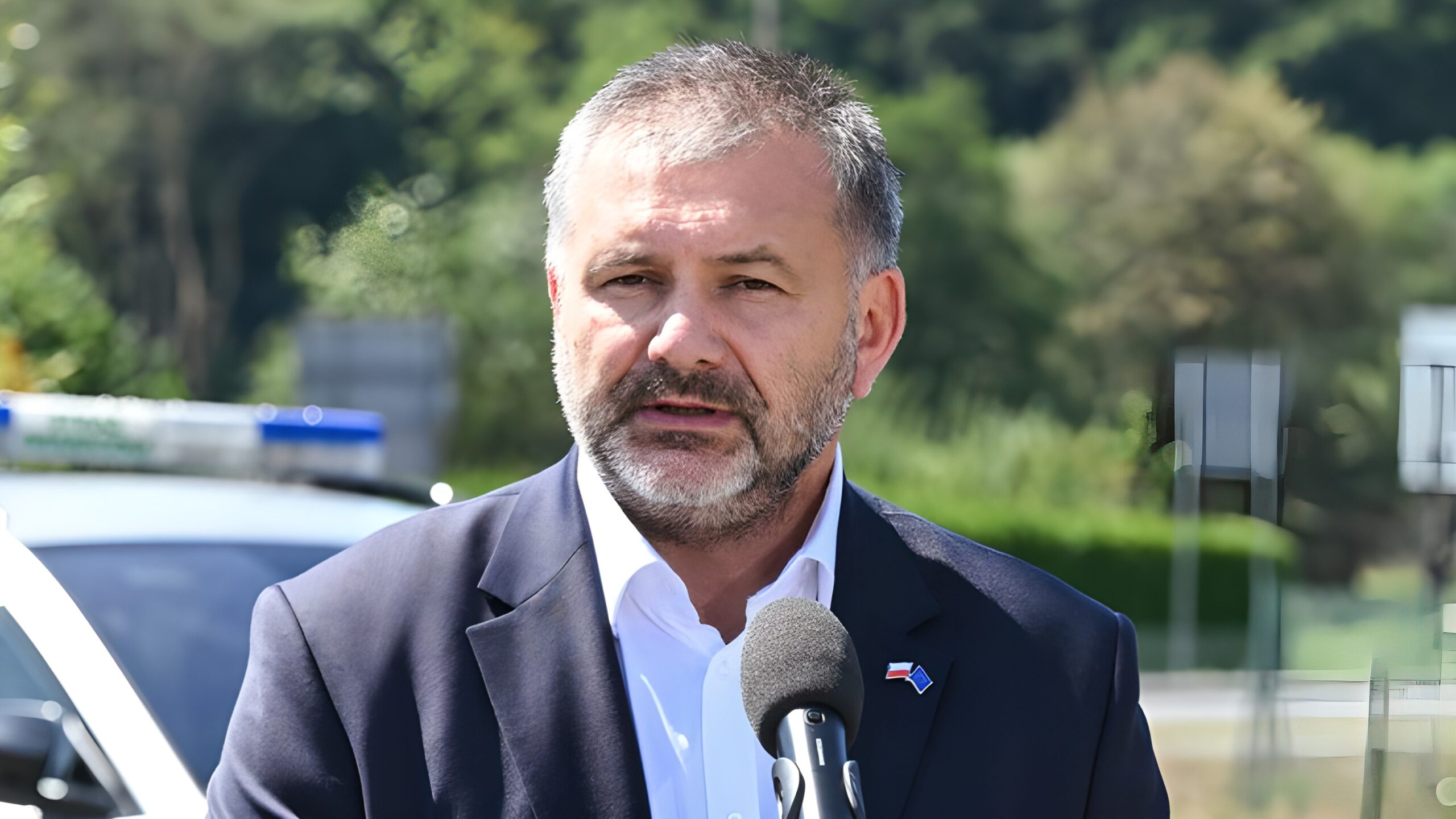 Minister sprawiedliwości Waldemar Żurek podczas wypowiedzi dla mediów na tle radiowozu